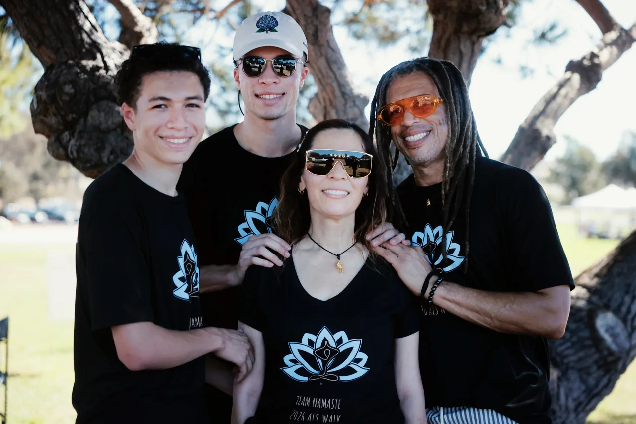 Natasha with her husband and two sons, wearing Team Namaste shirts