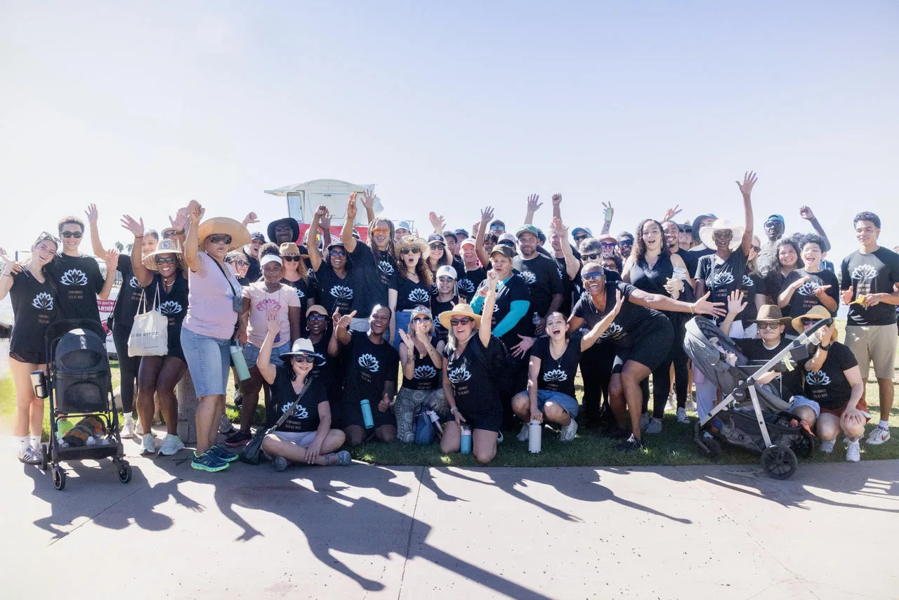 Team Namaste gathered together at the 2026 Walk to Defeat ALS, arms raised and smiling